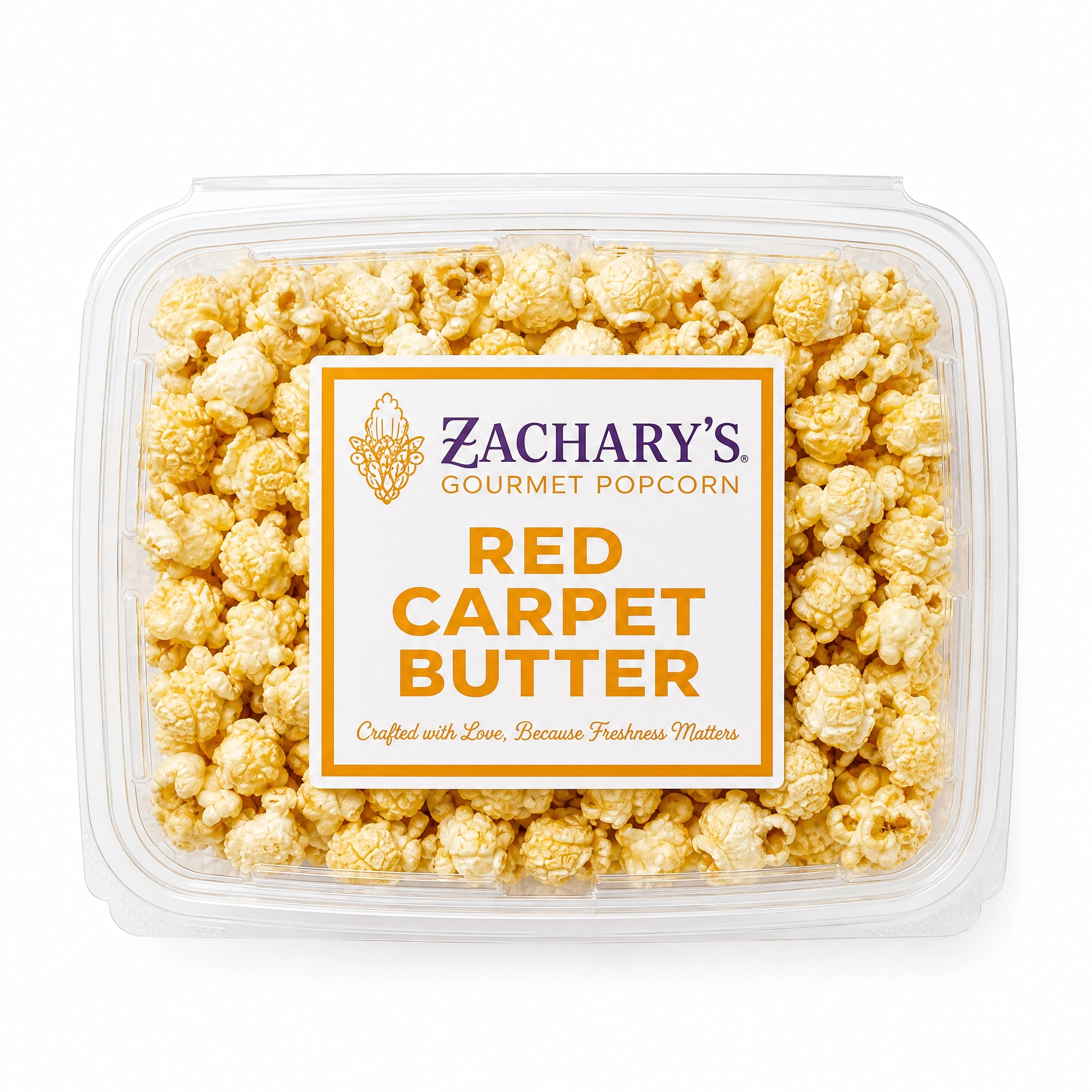 Close-up of Zachary's Red Carpet Butter gourmet popcorn in a clear clamshell container, classic golden buttery kernels with gold and white label