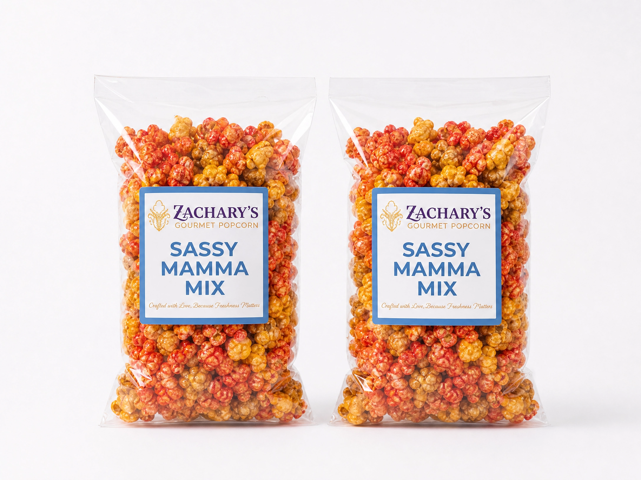 Two standard-size bags of Zachary's Sassy Mamma Mix gourmet popcorn, sweet and savory caramel-Cheddar, spicy kernel blend with blue and white label
